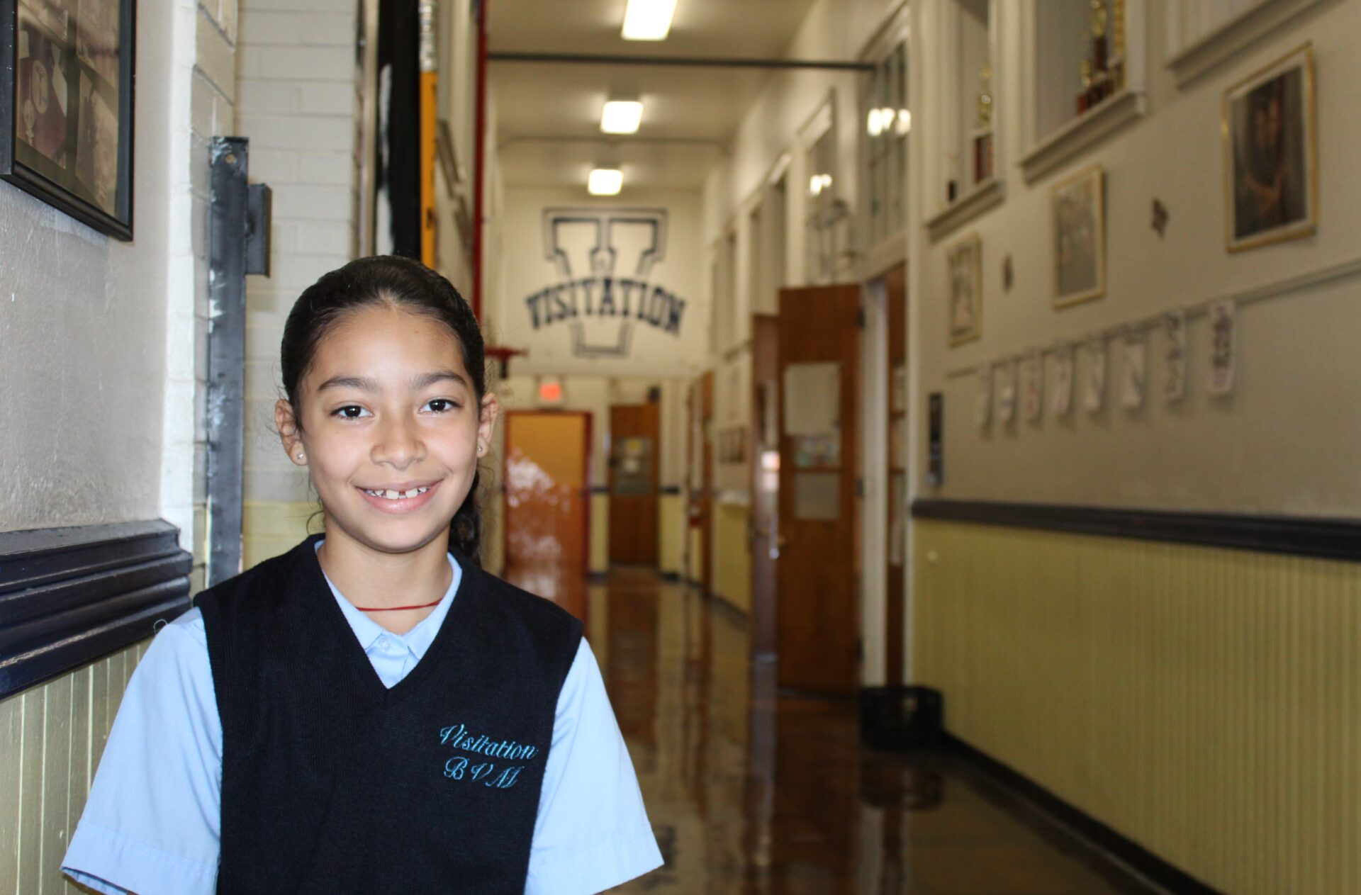 Student smiles while standing in the hallway