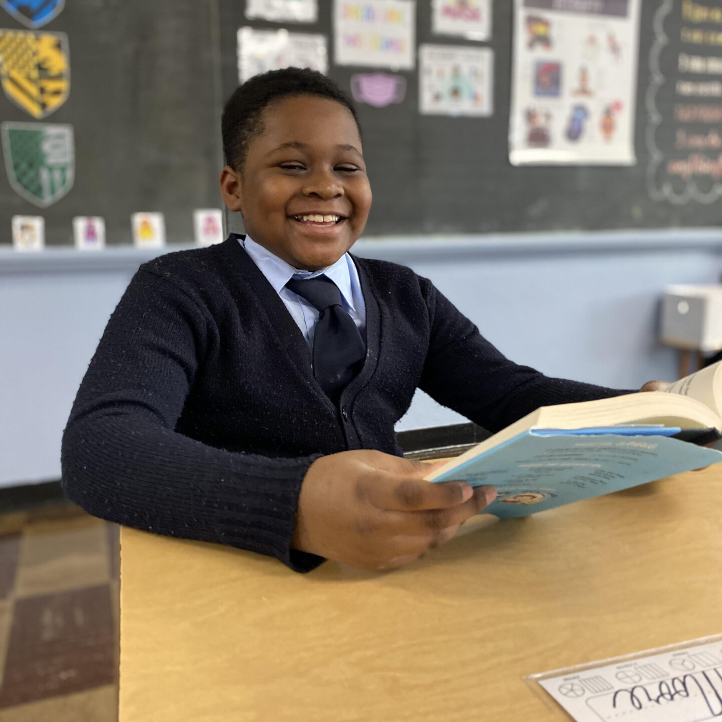 Boy looking up from book smiling